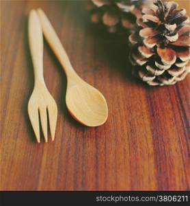 Wooden spoon and fork with pine cone, retro filter effect
