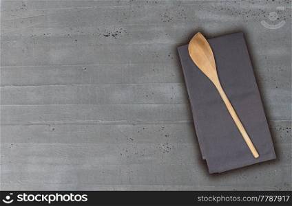 Wooden spoon and kitchen towel on concrete background.. Wooden spoon and kitchen towel on concrete background