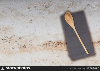 Wooden spoon and kitchen towel on marble.. Wooden spoon and kitchen towel on marble