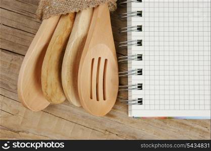 wooden spoon and notebook on old wooden table