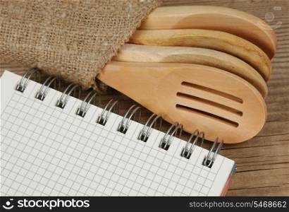 wooden spoon and notebook on old wooden table