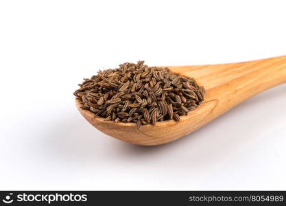 Wooden spoon and pile of cumin seeds isolated on white background