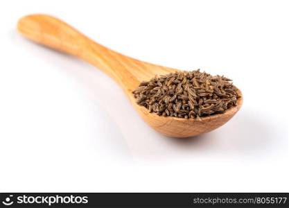 Wooden spoon and pile of cumin seeds isolated on white background