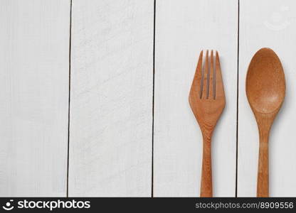 Wooden spoon and wooden fork on white wooden floor.. Wooden spoon and wooden fork on white wooden floor background for design in your work.