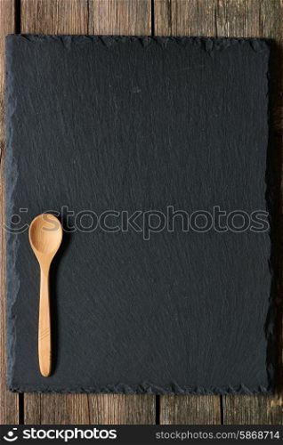 Wooden spoon on slate background