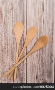 Wooden spoon tied up with a ribbon on rustic background. Top view with copy space.