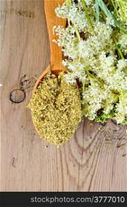Wooden spoon with dried flowers of meadowsweet, a bouquet of fresh flowers of meadowsweet on a wooden board