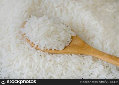 Wooden spoon with rice lying against the background rice. Wooden spoon with rice