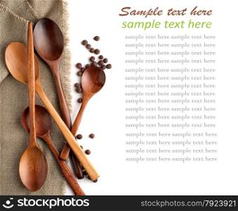 wooden spoons and black pepper on a linen napkin and sample text