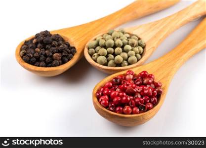 Wooden spoons with various pepper spice on white background