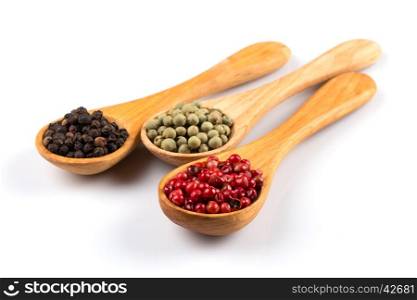 Wooden spoons with various pepper spice on white background