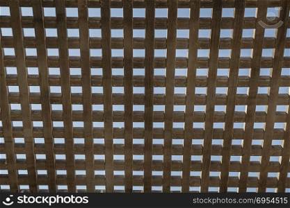 Wooden square grid in color with blue sky.