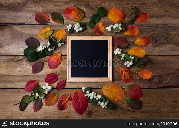Wooden square picture frame mockup with fall leaves and ghostberries. Empty frame mock up for presentation design. Template framing for modern art.