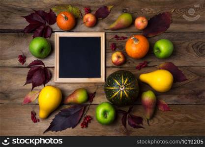 Wooden square picture frame mockup with pumpkins, apples, pears on the rustic background. Empty frame mock up for presentation design. Template framing for modern art.