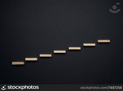 Wooden stair on black background , career growth and progress concepts.
