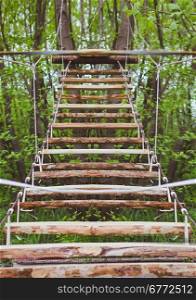 Wooden stairs in the green forest park. Wooden stairs in the green forest park with ropes