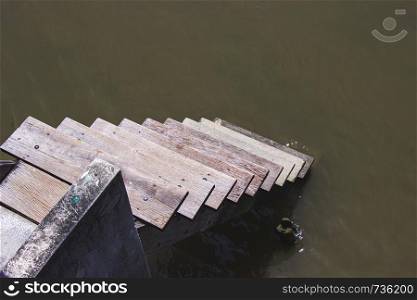 Wooden stairs on the way down the river or canal traditional style of the countryside of Thailand.