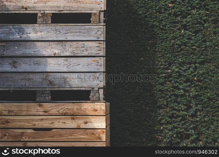 Wooden storage crates for commercial transportation of vegetables. Outdoor storage of empty wooden boxes. Outdoor warehouse with plant walls.