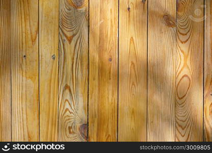 Wooden surface of boards illuminated by light rays. Copy space.