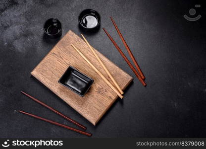 Wooden sushi sticks on a dark concrete background. Japanese Asian cuisine. Wooden sushi sticks on a dark concrete background