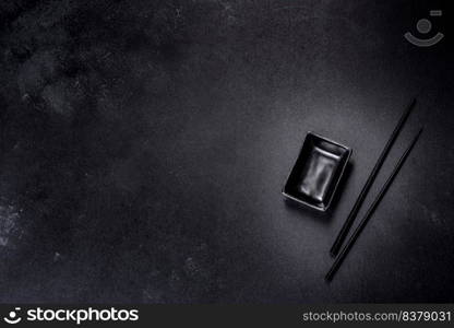 Wooden sushi sticks on a dark concrete background. Japanese Asian cuisine. Wooden sushi sticks on a dark concrete background