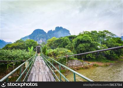 Wooden suspension bridge crossing the river Vang Vieng Laos