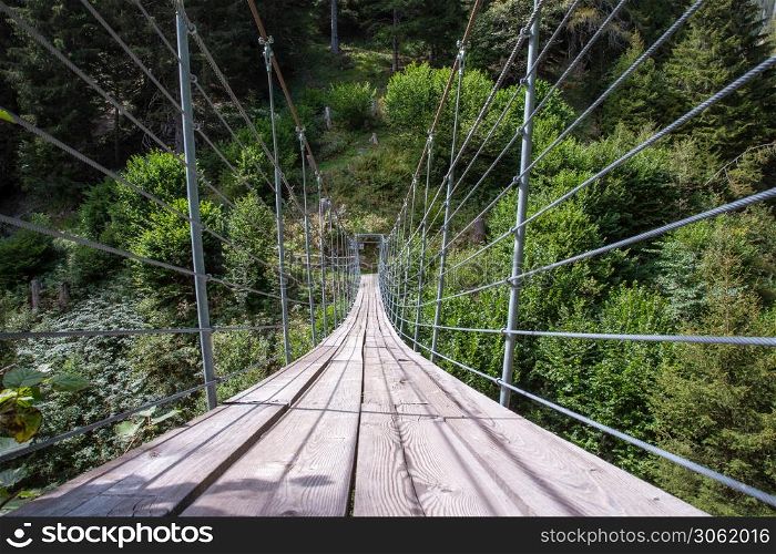 wooden suspension bridge in the forest beautiful mountain landscape in the summer. wooden suspension bridge in the forest beautiful mountain landscape
