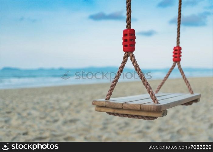 Wooden swing on tropical beach