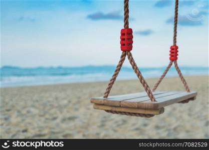Wooden swing on tropical beach