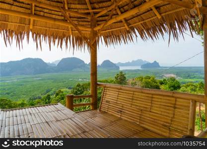 Wooden table and chairs in thai pavilion at Samet Nangshe Viewpoint with sea in Phang Nga Bay, tourist attraction in summer season, Thailand in travel trip and holidays vacation. Natural landscape.