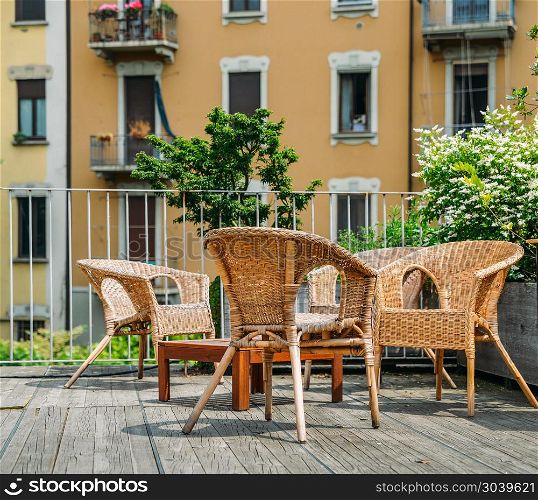 Wooden table and chairs on an outdoor terrace in a residential neighbourhood during the summer.. Wooden table and chairs on an outdoor terrace in a residential neighbourhood during the summer