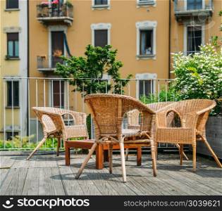 Wooden table and chairs on an outdoor terrace in a residential neighbourhood during the summer.. Wooden table and chairs on an outdoor terrace in a residential neighbourhood during the summer