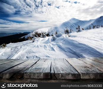 Wooden table and winter background with mountains. Wooden table and winter background