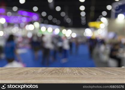 wooden table for display or montage your product with blur background of people in exhibition hall building
