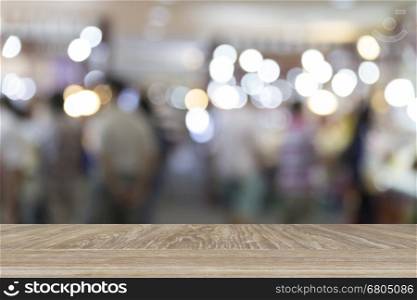 wooden table for display or montage your product with blur background of people in department store for use as shopping concept