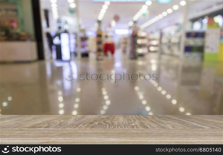 wooden table for display or montage your product with blur background of bokeh light of retail shop in department store
