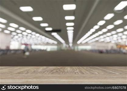 wooden table for display or montage your product with blur background of people in airport terminal