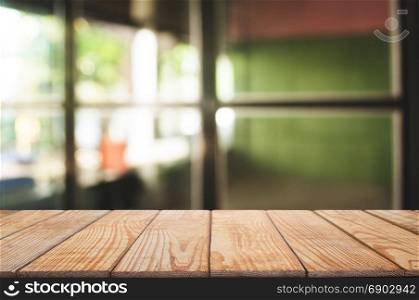 wooden table platform over blurred coffee shop cafe / home background