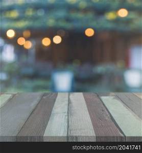 wooden table top front garden with blurred bokeh lights