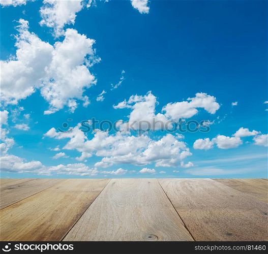 wooden table top with beautiful sky with clouds