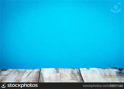 Wooden table top with blue wall background