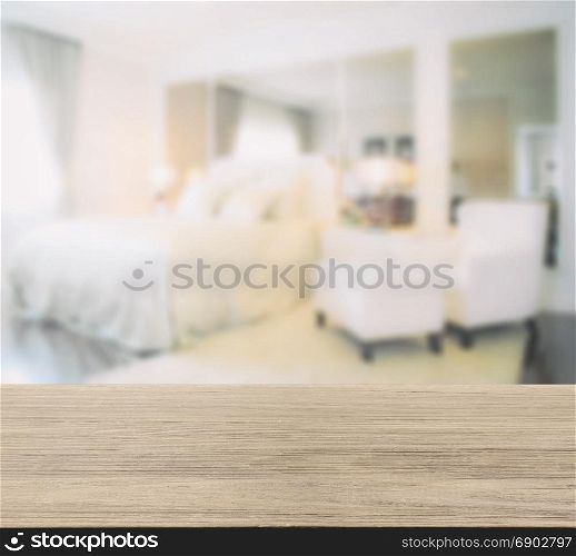 wooden table top with blur image of bedroom interior modern style