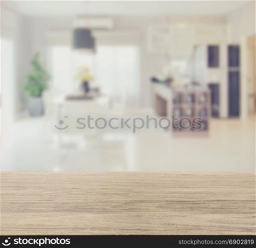 wooden table top with blur image of modern dining room interior