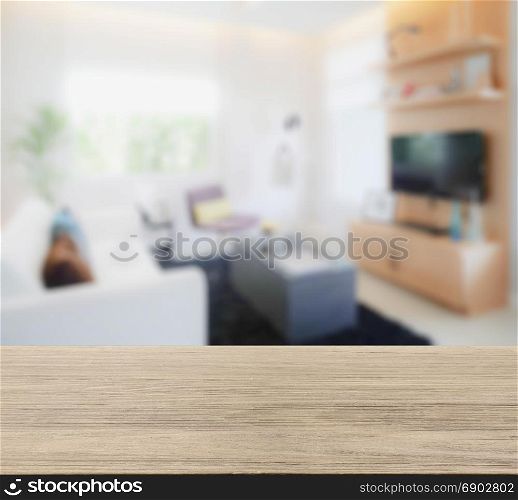 wooden table top with blur image of modern living room interior