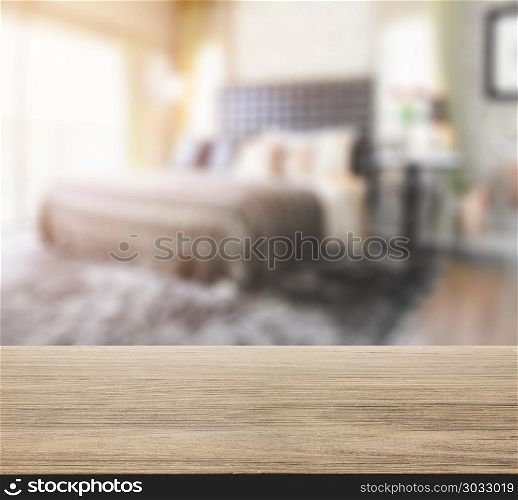 wooden table top with blur of bedroom in modern interior style
