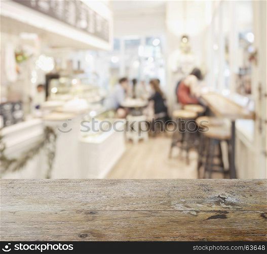 wooden table top with blur of coffee shop interior as background