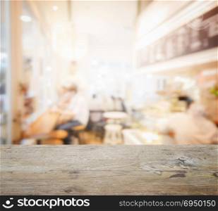 wooden table top with blur of coffee shop interior as background