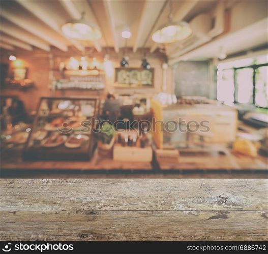 wooden table top with blur of coffee shop interior background