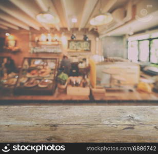 wooden table top with blur of coffee shop interior background