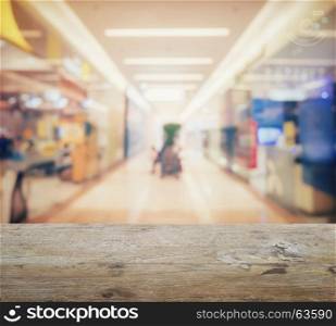 wooden table top with blur of department store with bokeh background.